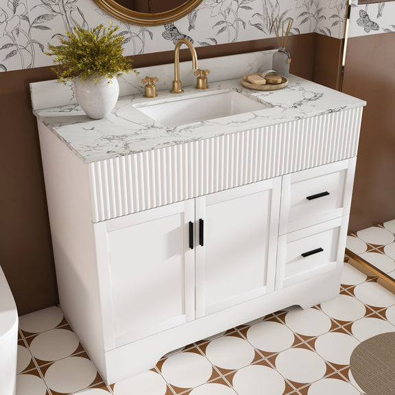White bathroom vanity with fluted front, marble-look countertop and sink, two drawers