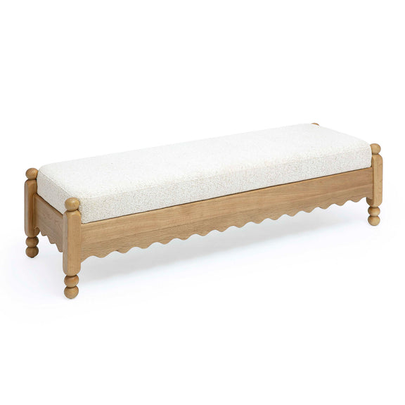 Cream upholstered bench with light wood frame and scalloped underside, four round legs.