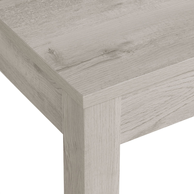 Close-up of gray wood dining bench corner and tabletop edge