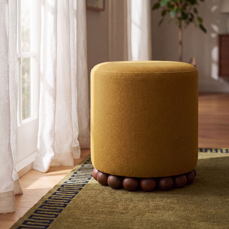 Bronze/gold round ottoman with plush fabric top and wooden ball base