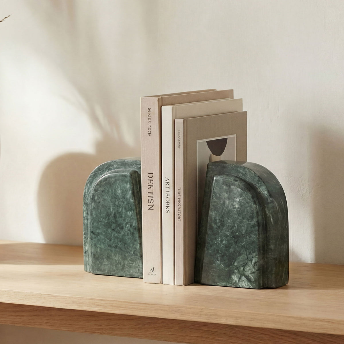Green marble bookends with rounded ends, stacked on a shelf beside books