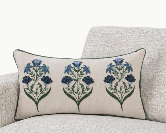 Floral lumbar pillow on sofa, natural base with blue flower sprays and green piping