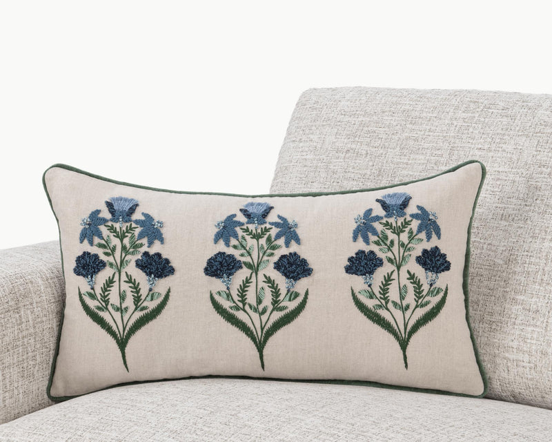 Floral lumbar pillow on sofa, natural base with blue flower sprays and green piping