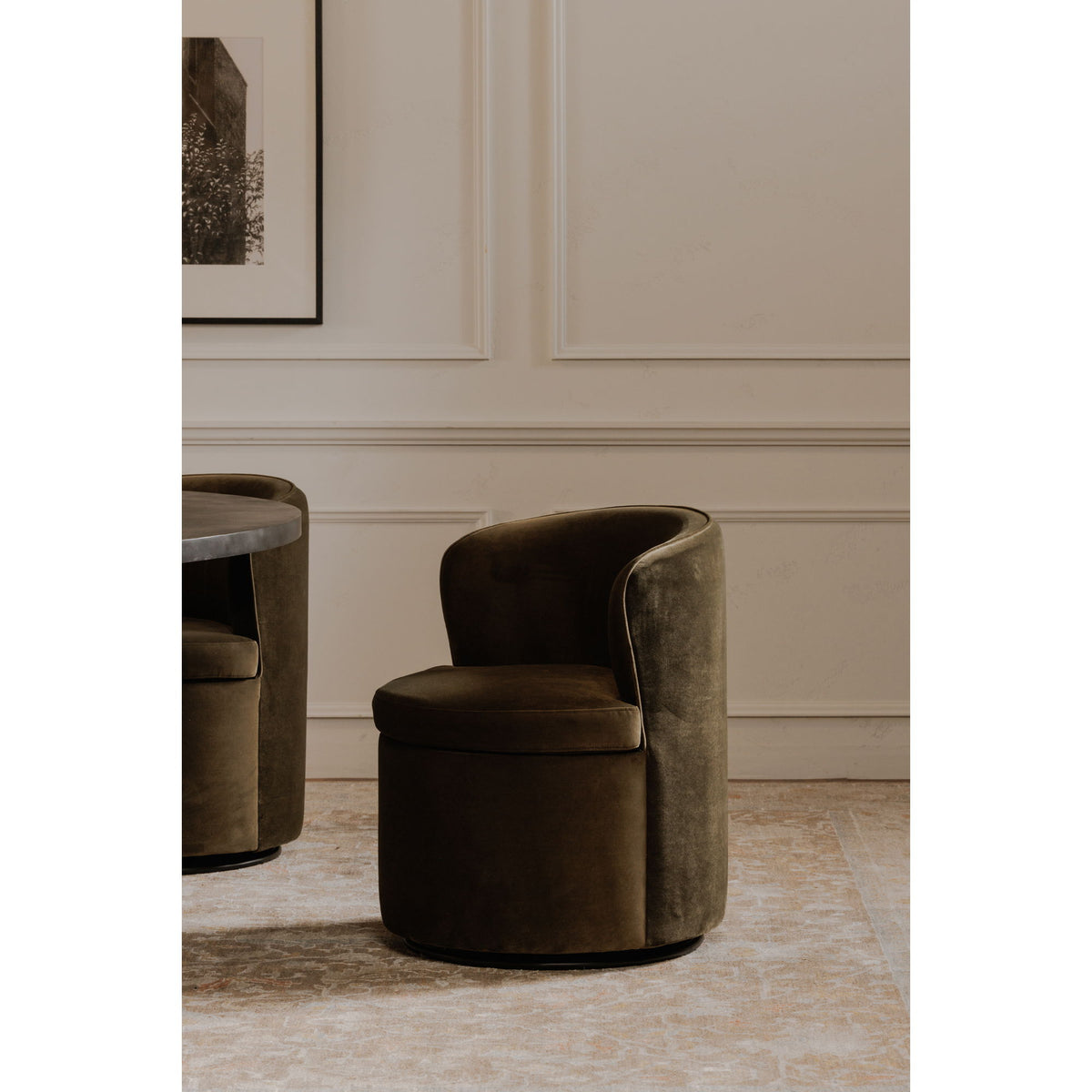 Green upholstered swivel chair with curved arms and cushioned seat