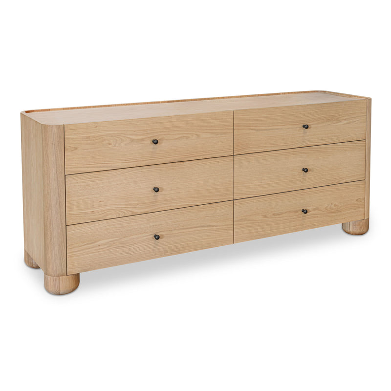 Light brown Gibson dresser shown at an angle, with six drawers and rounded feet