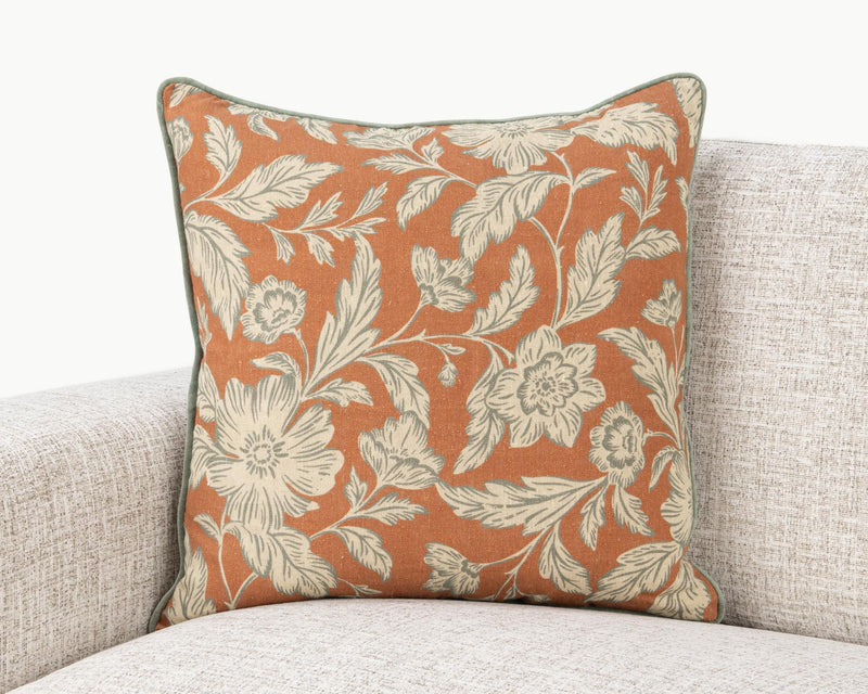 Rust floral square pillow with cream leaves and flowers and green edge piping