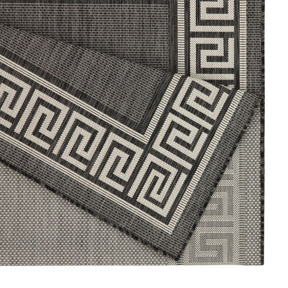 Indoor/outdoor area rug corner detail with dark gray border, Greek key trim