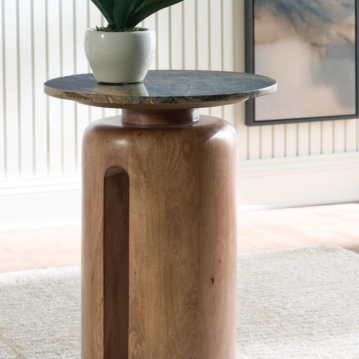 Brown wood accent table with round green patterned top on pedestal base