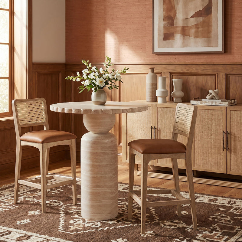 Beige round indoor/outdoor table with pedestal base in a dining setup