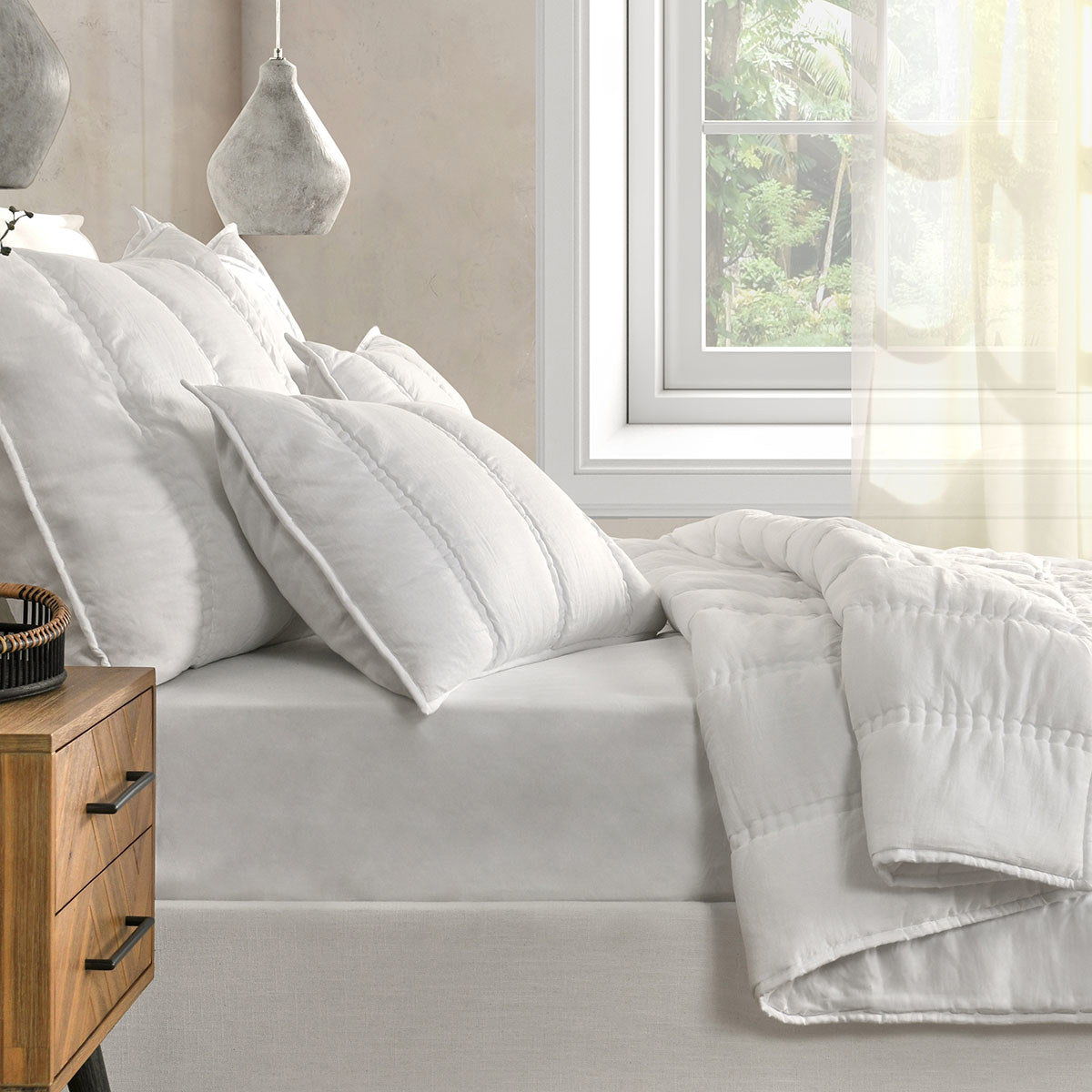 White pillow shams with vertical channel stitching on a sofa bed
