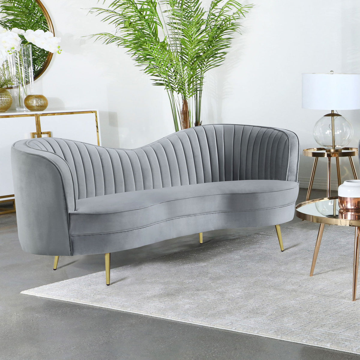 Light gray velvet loveseat with channel tufted back, curved arms, and gold legs