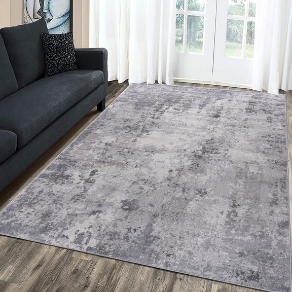 Light gray abstract area rug, rectangular, distressed pattern on wooden floor