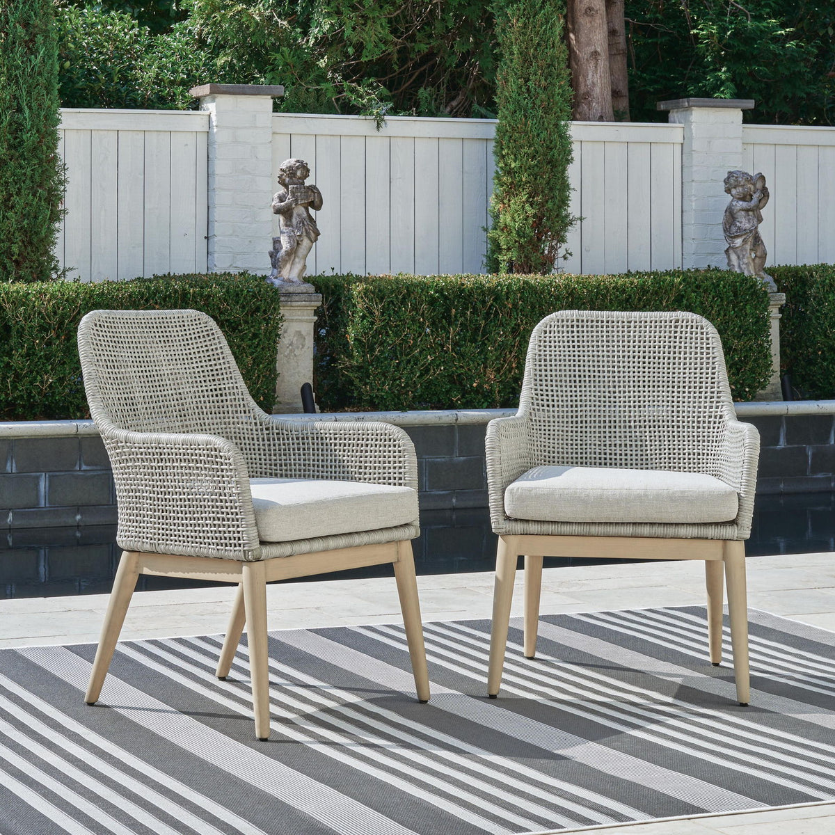 Two gray woven armchairs with seat cushions and light wood legs