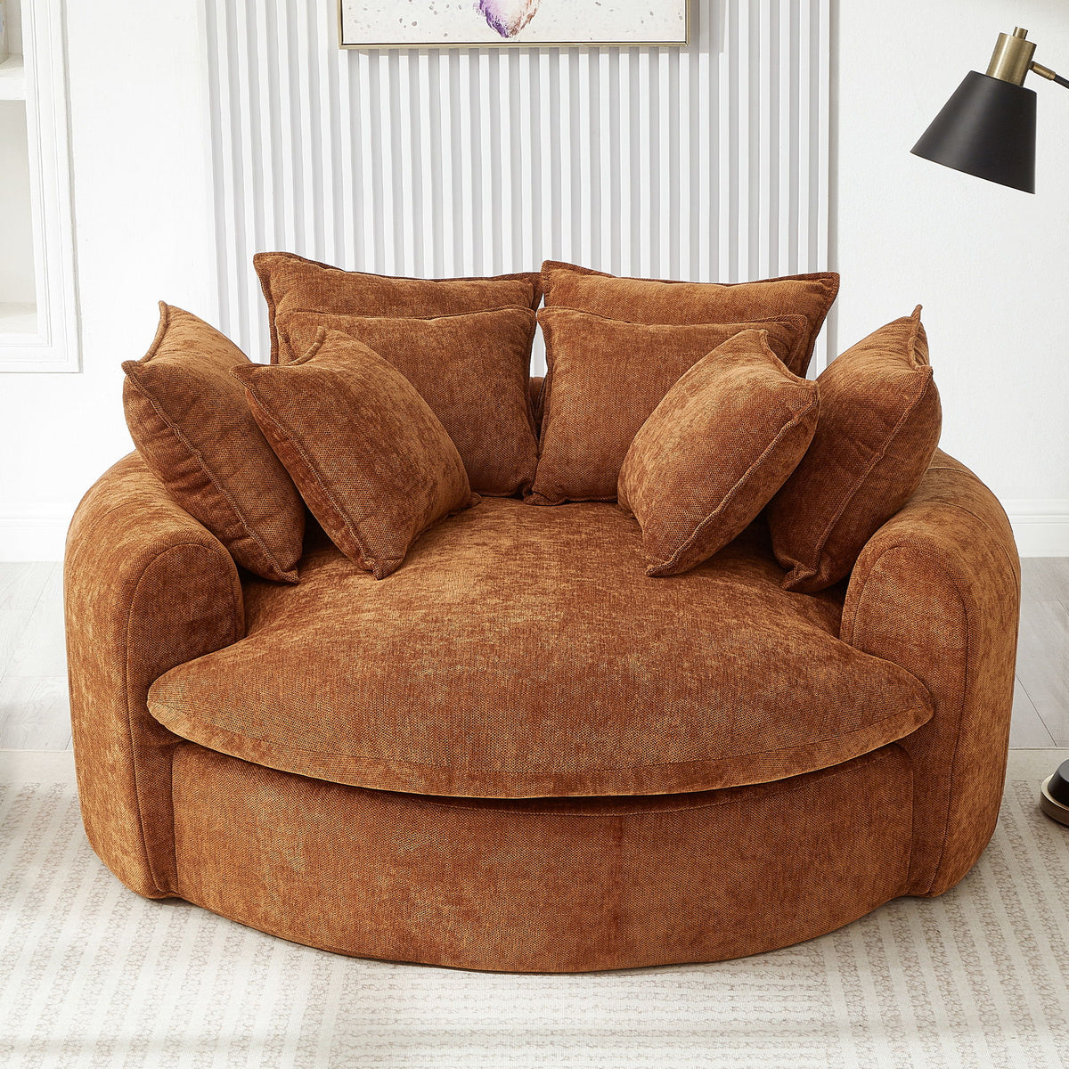 Round orange chaise sofa with matching throw pillows and curved arms