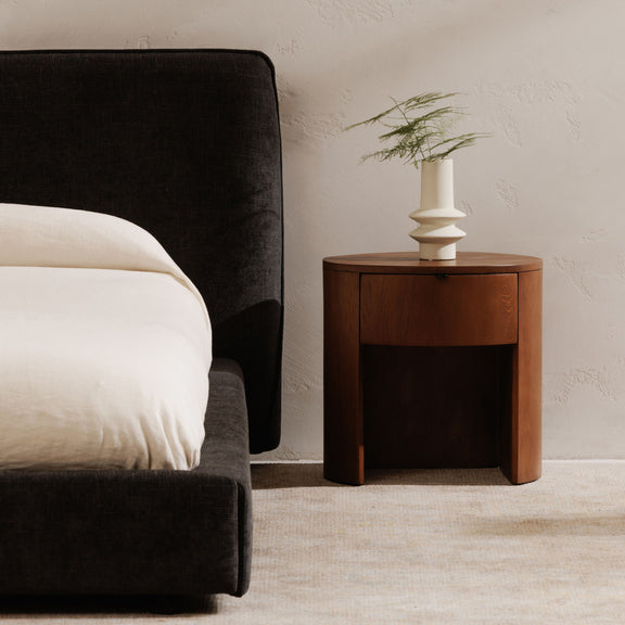 Brown one-drawer nightstand with round top and recessed drawer panel