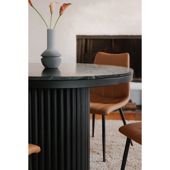 Round black dining table close-up of fluted pedestal and stone-look tabletop