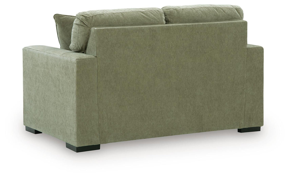 Green upholstered loveseat with square arms, tufted back cushions, and black legs