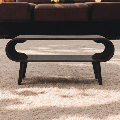 Dark brown oval coffee table with carved apron and tapered legs