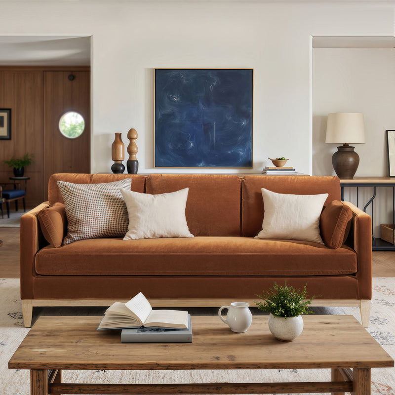 Modern farmhouse sofa in warm orange-brown fabric with rolled arms and three-seat cushions