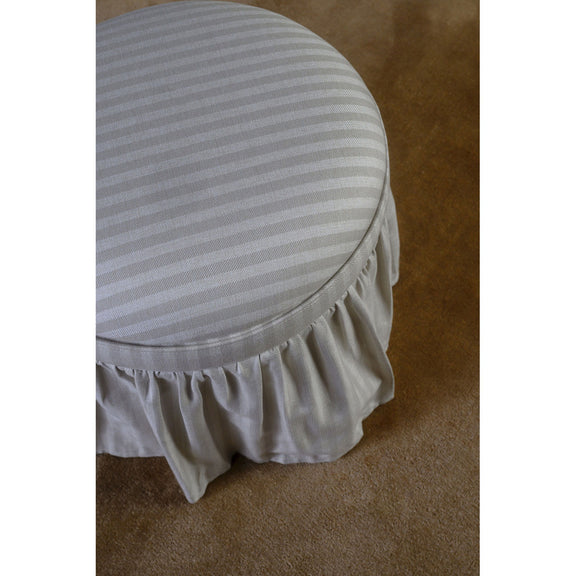 Beige striped storage ottoman close-up: round lid with pleated ruffled skirt