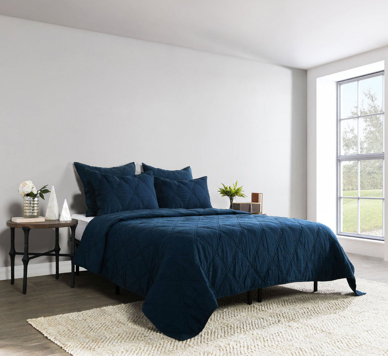 Blue quilted shams on bed with matching comforter