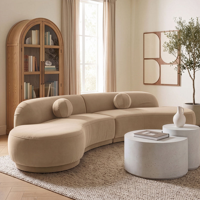 Light beige velvet sectional sofa with rounded arms and accent bolsters