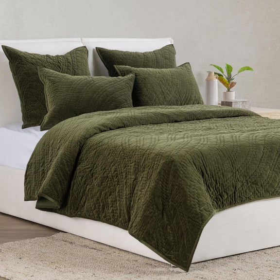 Dark green velvet pillow sham on bed with textured surface and neat seams