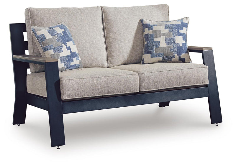 Blue outdoor loveseat with beige cushions and two blue-and-white square throw pillows