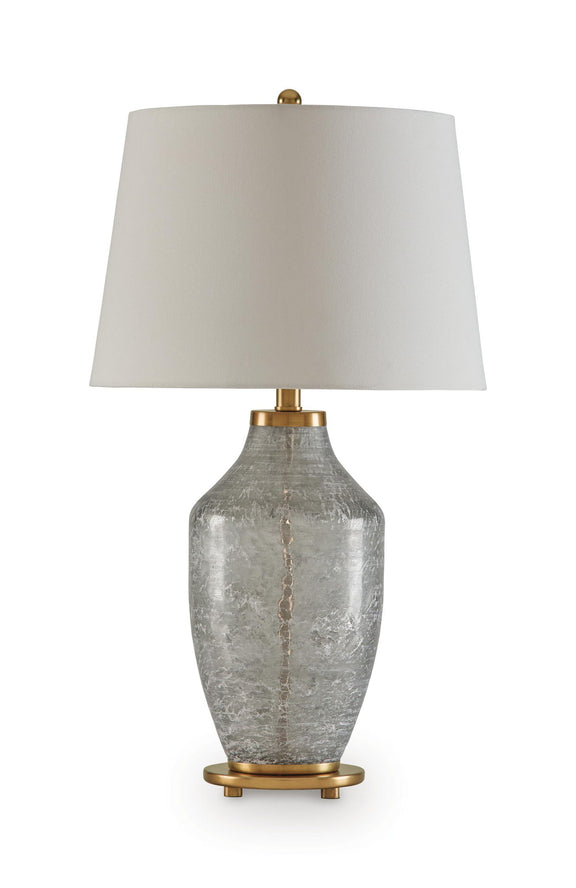 Glass table lamp with textured clear-gray base, beige fabric shade, and brass accents