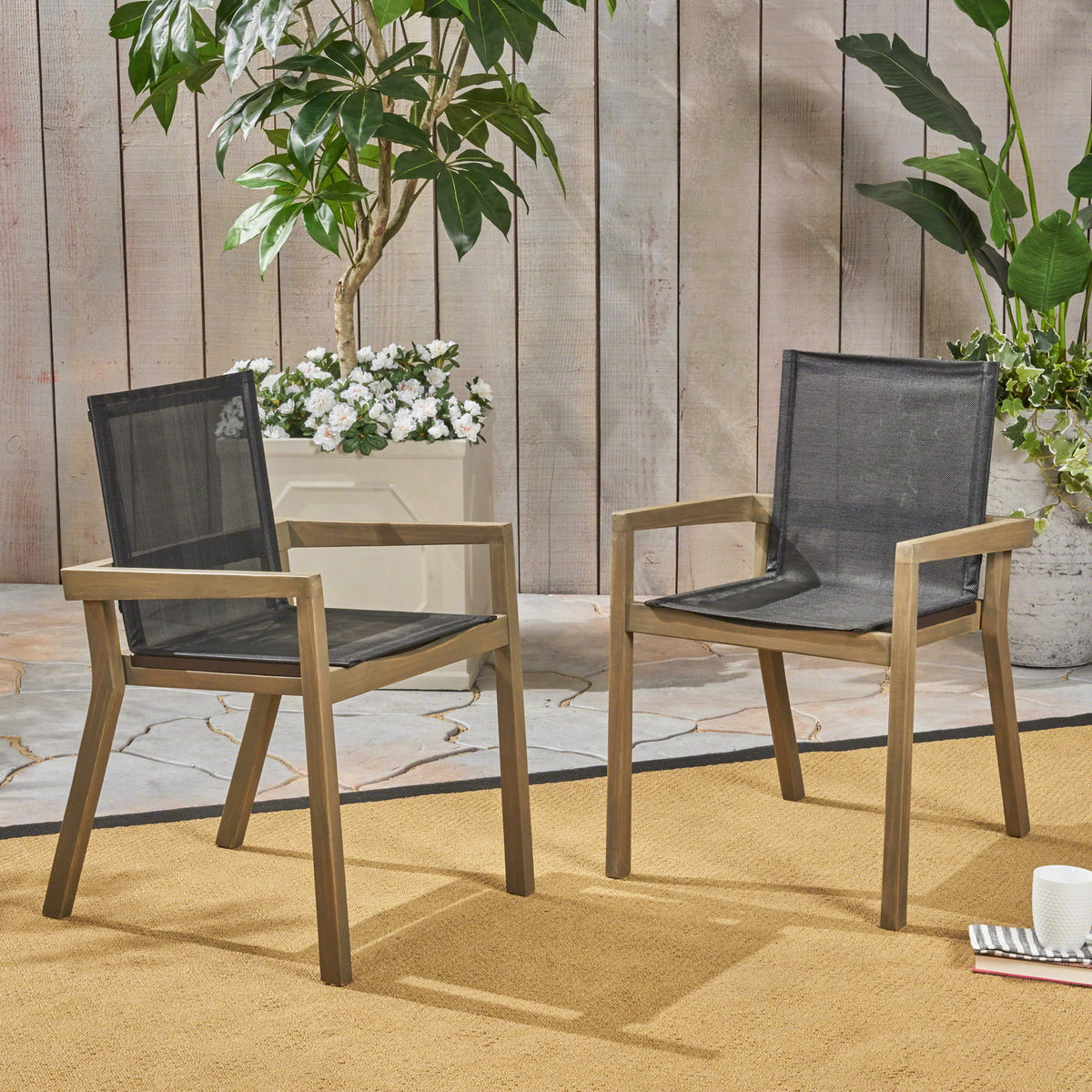 Pair of outdoor dining chairs with gray mesh seats and backs, brown frames, and armrests