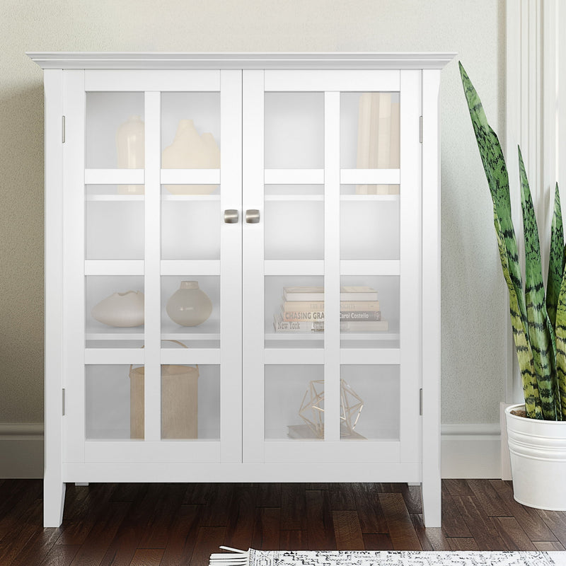 White storage cabinet with two glass doors and interior shelves for display and storage.
