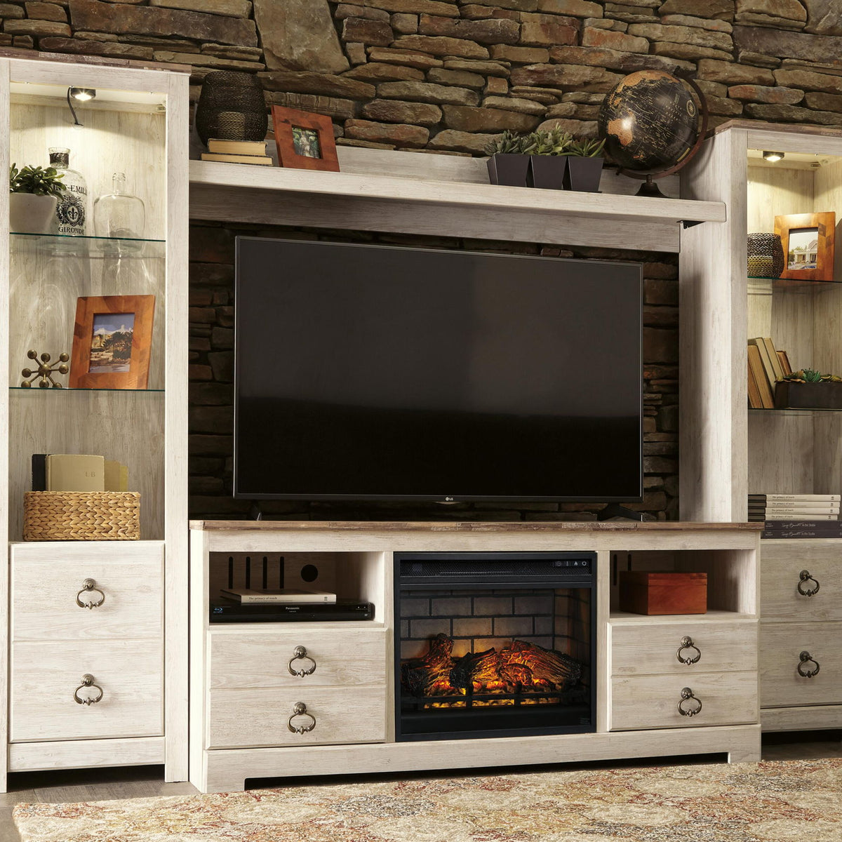 Whitewash entertainment center TV stand with dark TV panel and faux firebrick fireplace insert