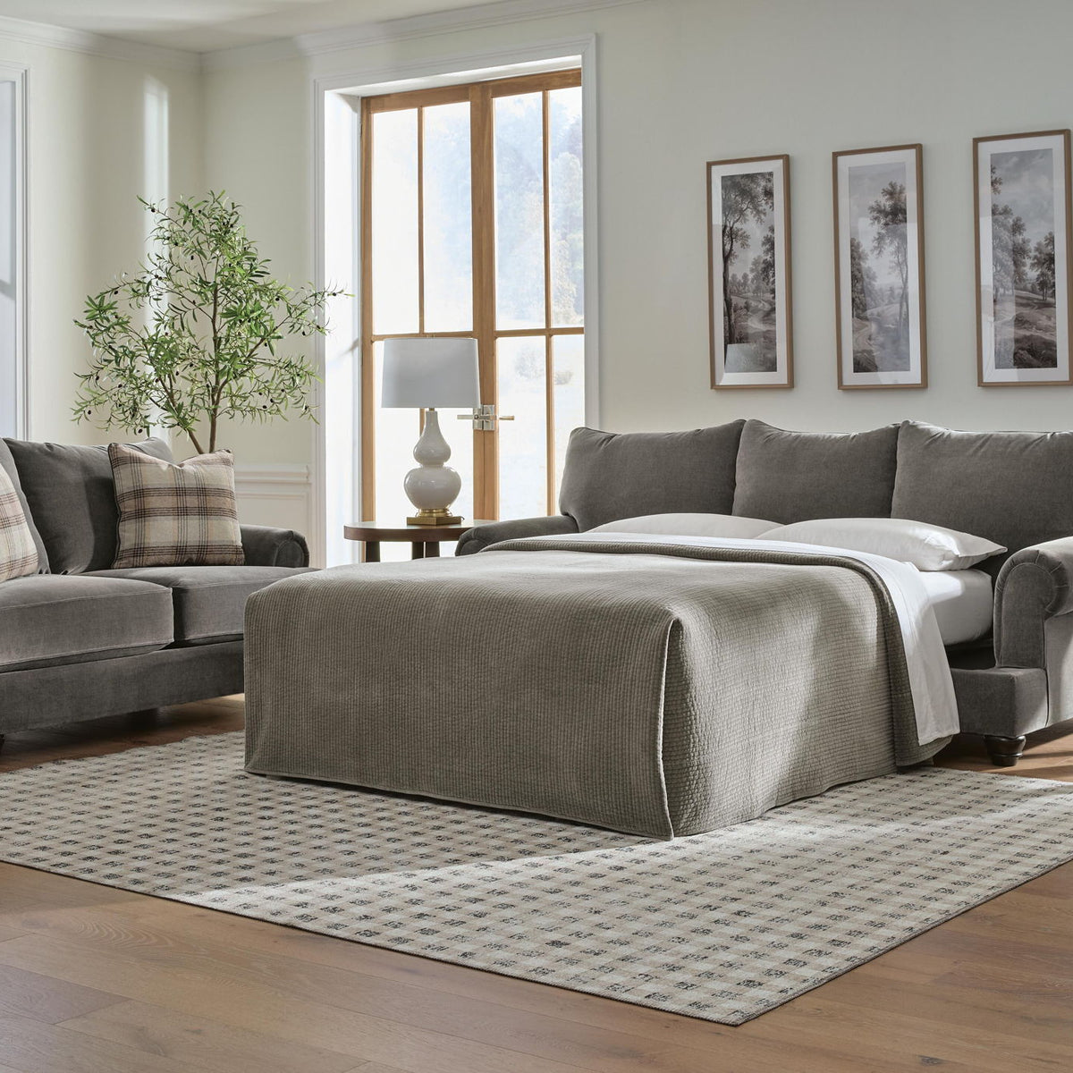 Queen sofa sleeper with open bed platform and dark gray cushions