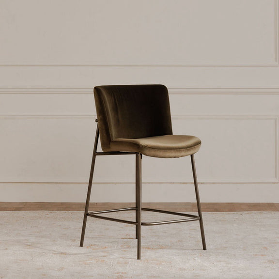 Green bar stool with upholstered back and seat, slim metal legs and footrest