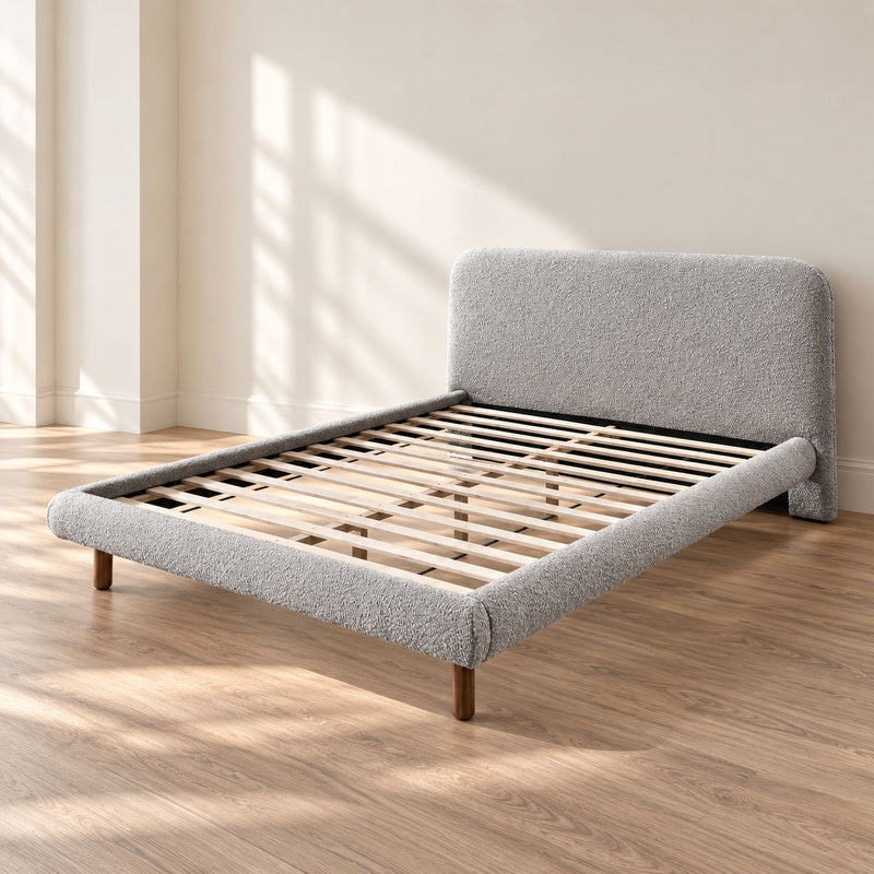 Gray upholstered platform bed with curved headboard, slatted base, and wooden legs