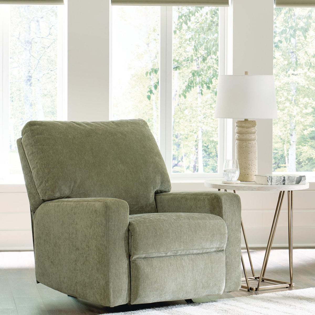 Green rocker recliner chair with padded arms, boxy seat, and recline backrest