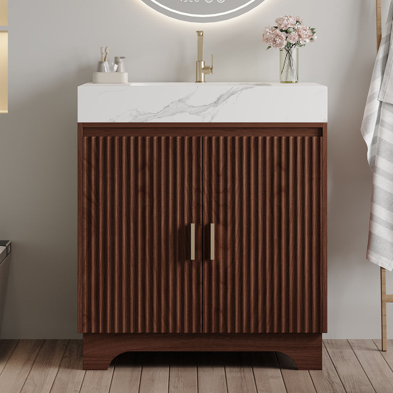 Close view of fluted walnut vanity doors, brass handles, and white marble-look sink top