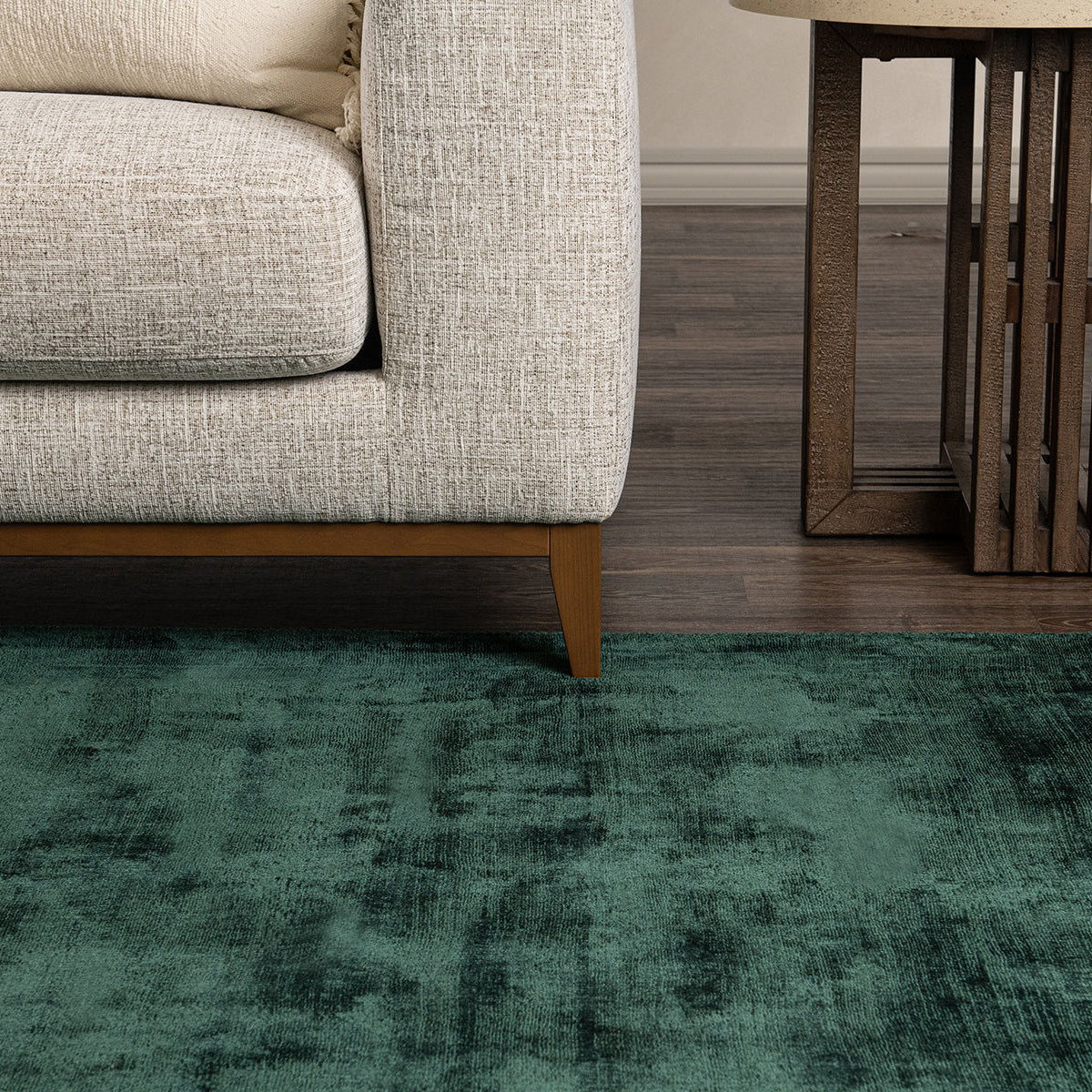 Dark green distressed area rug with clouded, vintage-style pattern and low pile.