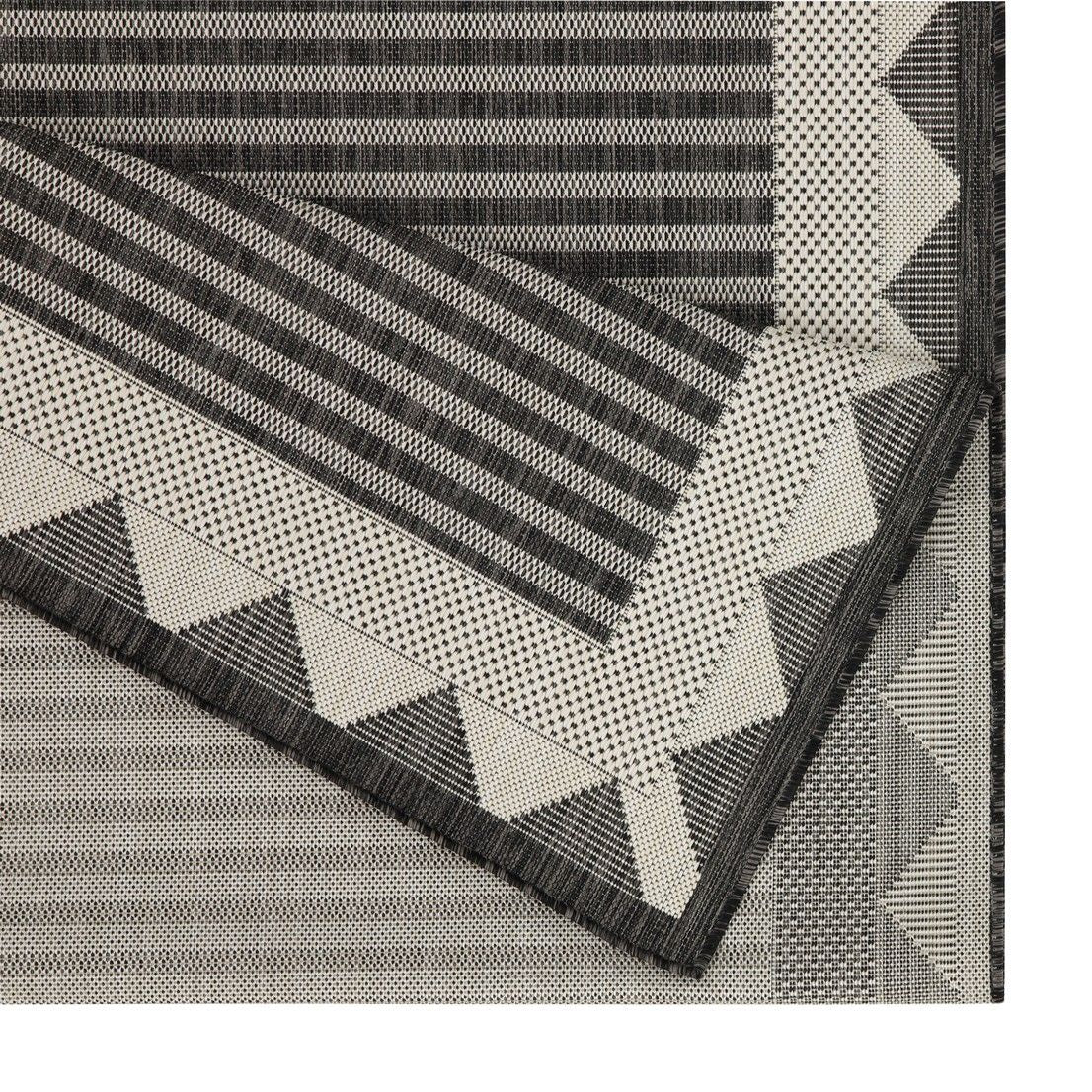 Charcoal and gray striped area rug detail with triangular border and zigzag trim