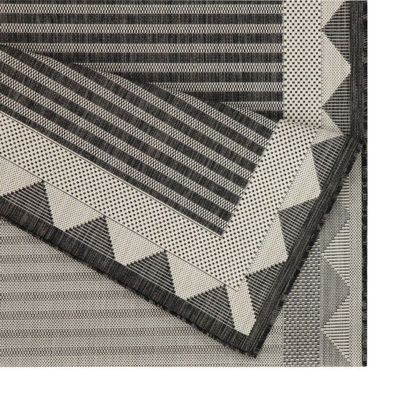 Charcoal and gray striped area rug detail with triangular border and zigzag trim
