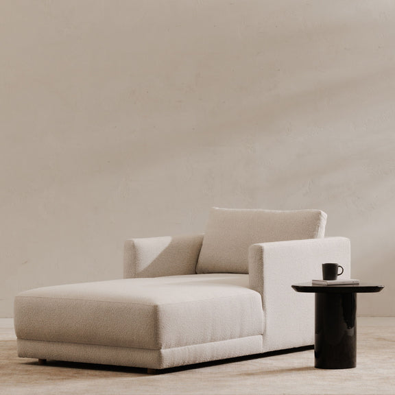 Light beige chaise lounge with deep seat, two back cushions, and thick armrests