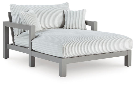 Gray chaise lounge with white striped chaise pad, folded armrest cushion, back pillows