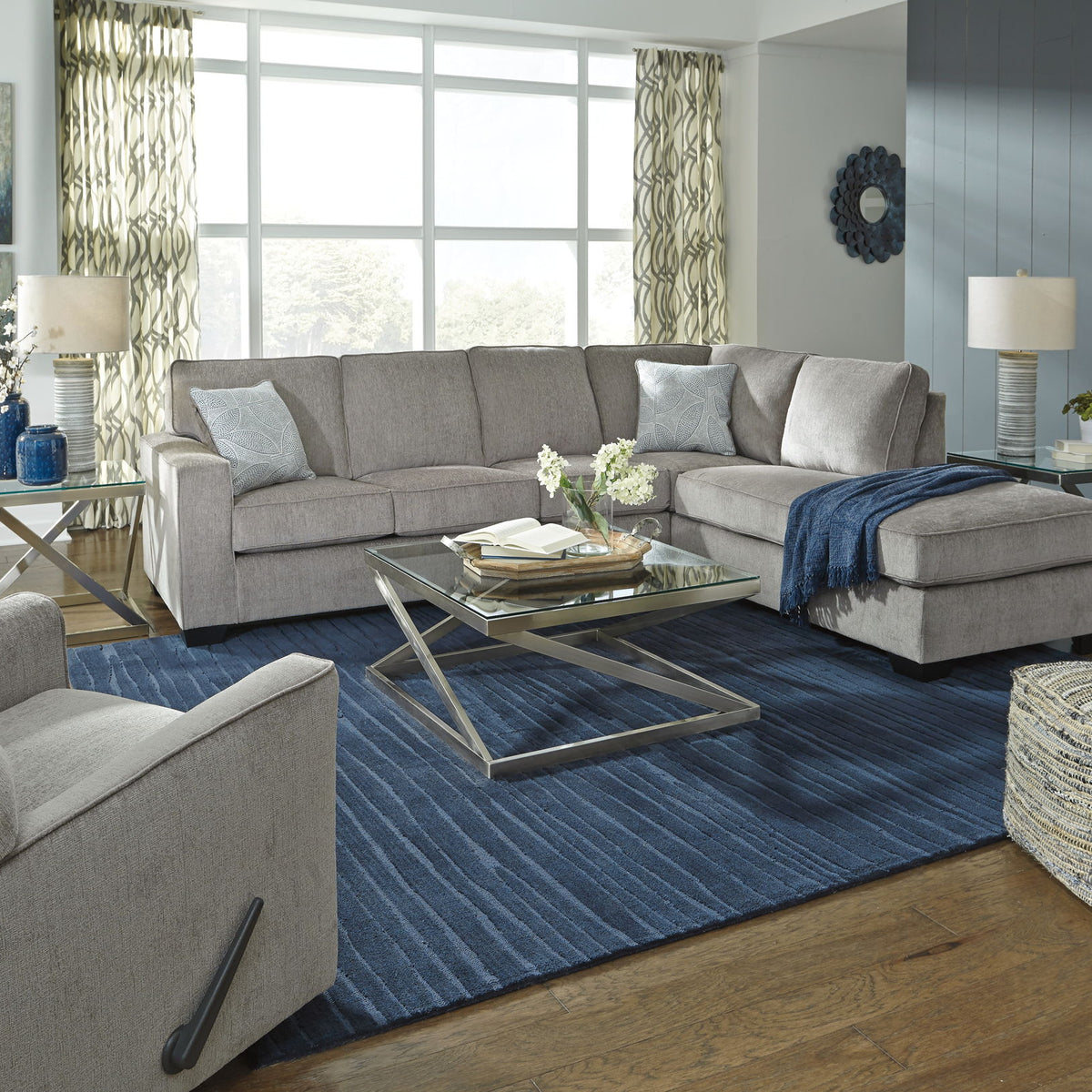 Light gray sectional sleeper sofa with chaise, back pillows, and neutral throw blanket