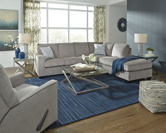Light gray sectional sleeper sofa with chaise, back pillows, and neutral throw blanket