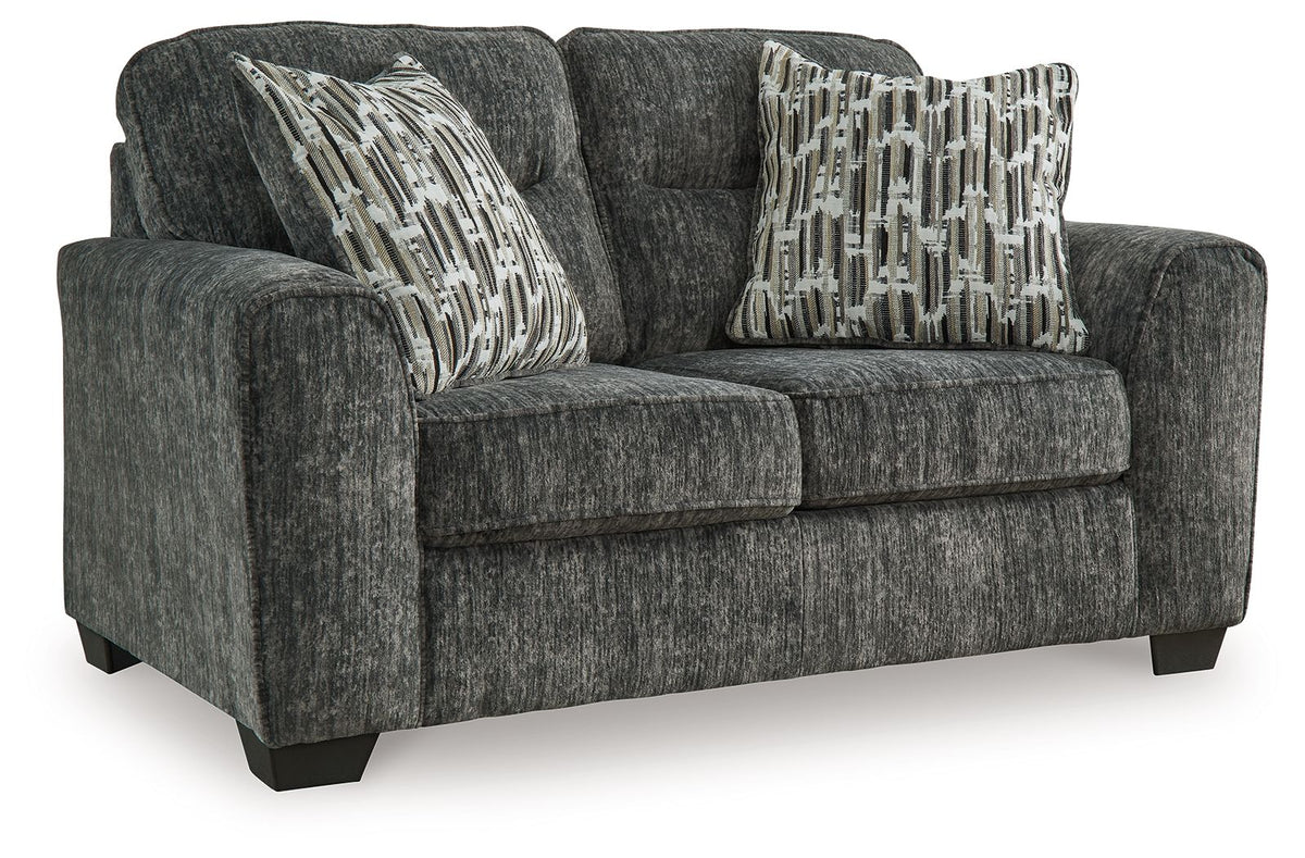 Gunmetal gray loveseat with two patterned throw pillows and tufted seat cushions