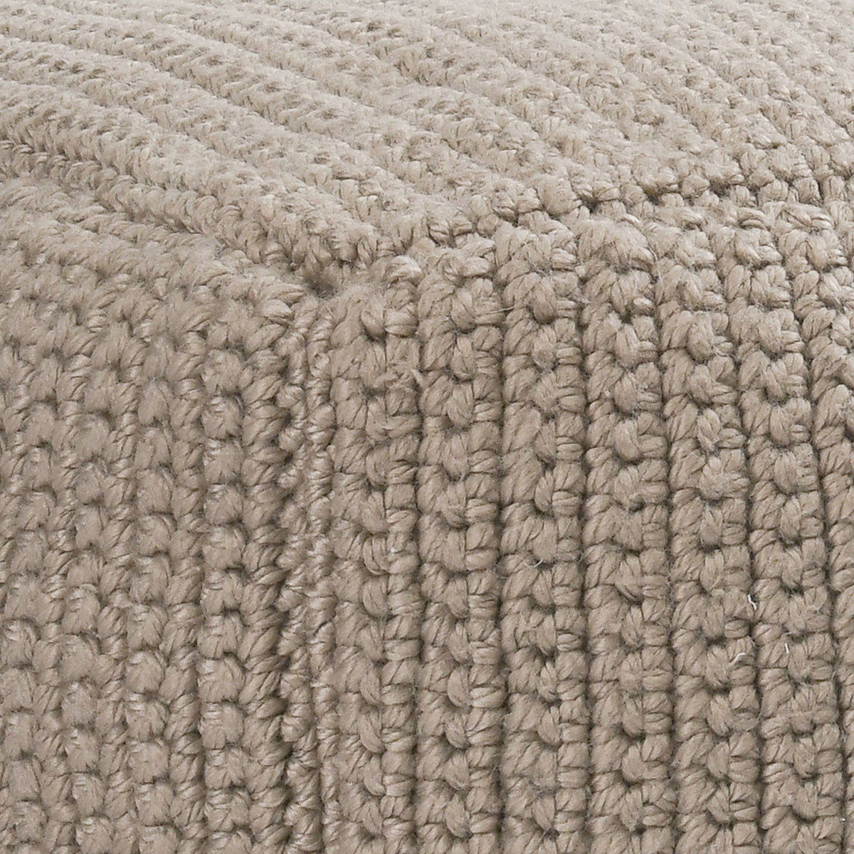 Natural beige knitted fabric close-up with chunky looped crochet texture