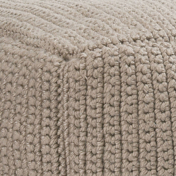 Natural beige knitted fabric close-up with chunky looped crochet texture