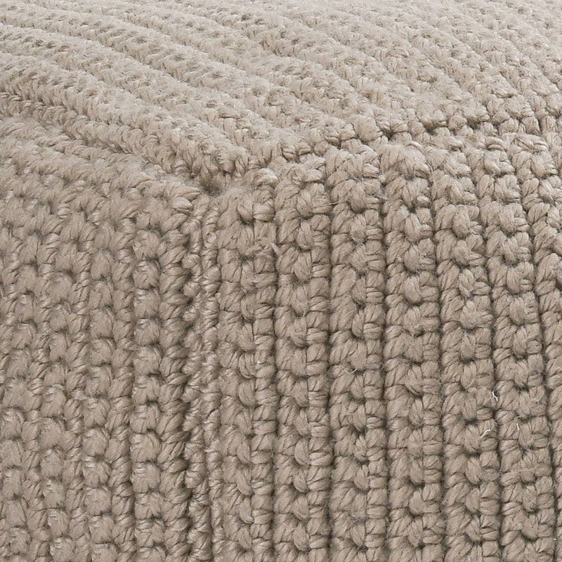 Natural beige knitted fabric close-up with chunky looped crochet texture