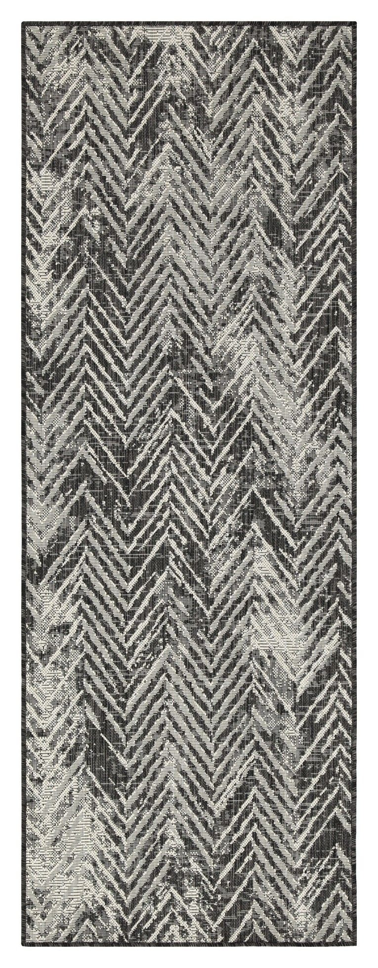 Indoor/outdoor area rug with dark gray and cream chevron pattern, narrow border.