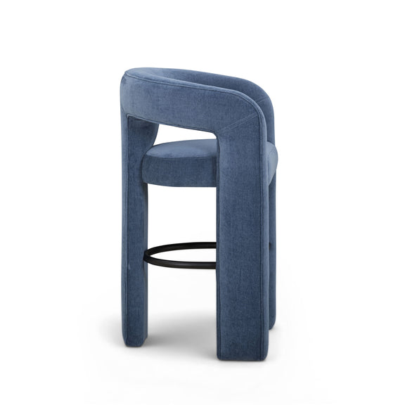 Upholstered stool in blue with thick backrest, curved legs, and black footrest ring